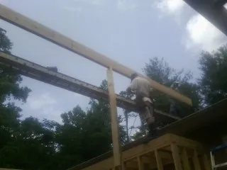 Carpenter setting a ridge beam over a new addition frame — Ice Dam Removal by Roofing Brothers in Prairie