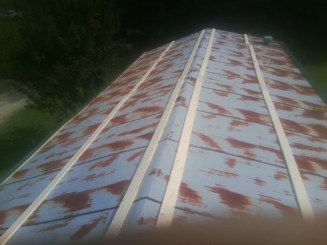 Rusted metal roof panels with new wood purlins before replacement — Storm Damage Roof Repair in Prairie by Roofing Brothers